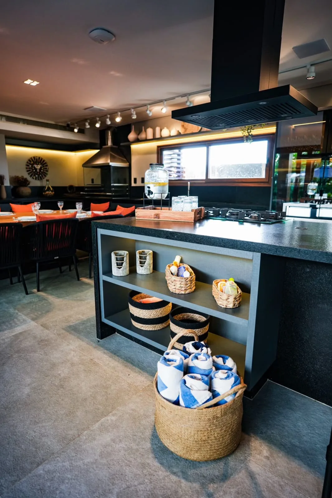 Ilha da cozinha com cestaria e utensílios, aberta para o estar