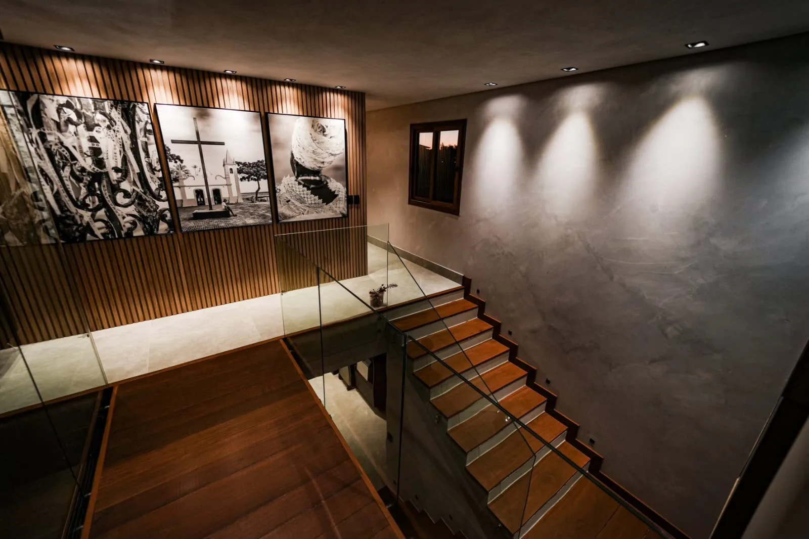 Vão da escada com painel artístico e iluminação cênica